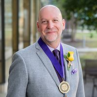 Patrick Evans with a medal around his neck in the BEC courtyard