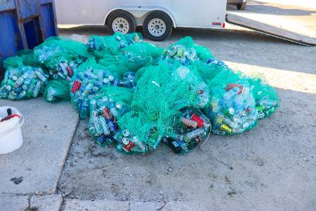 A group of clear stream recycling bins on the ground. 